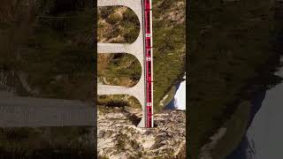 Landwasser viaduct a birds eye view as a Swiss train passes through train switzerland drone [upl. by Aland939]